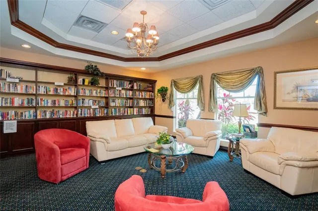 a living room with patio furniture and a chandelier