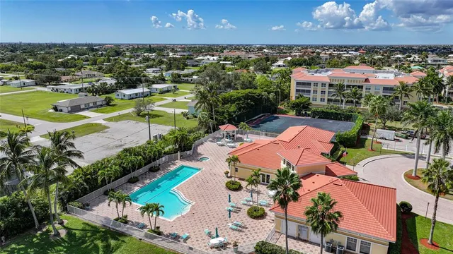 an aerial view of residential houses with outdoor space and trees