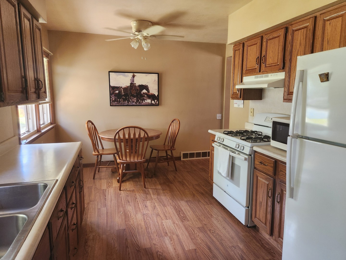 45 Locust Street Prophetstown, IL 61277 - Photo 5 of 14 a kitchen with stainless steel appliances granite countertop a stove top oven a dining table and chairs with wooden floor
