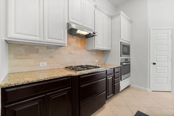 a kitchen with stainless steel appliances granite countertop white cabinets and a stove