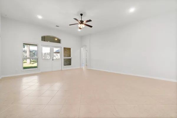 an empty room with windows and fireplace