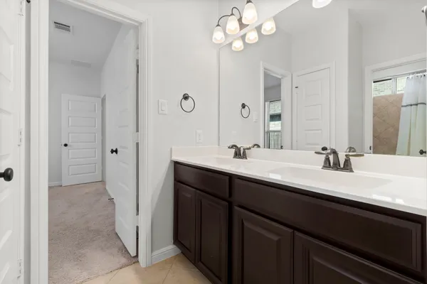 a bathroom with a double vanity sink a mirror and a shower