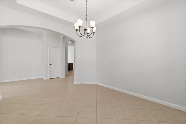 a view of an empty room with chandelier