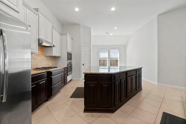 a kitchen with stainless steel appliances granite countertop a refrigerator and a stove