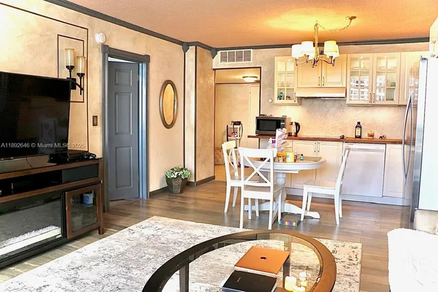 a dining room with wooden floor and chandelier