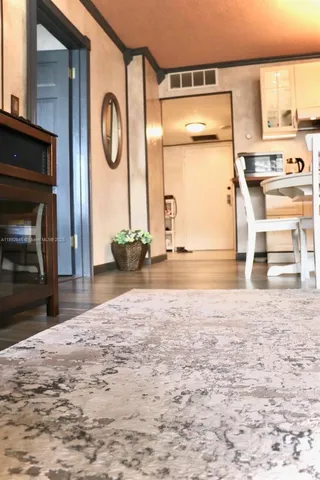a view of a livingroom with wooden floor and a fireplace