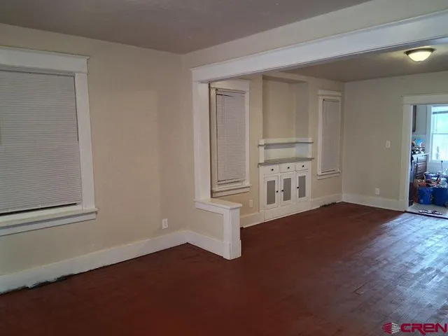 a view of empty room with wooden floor and cabinet