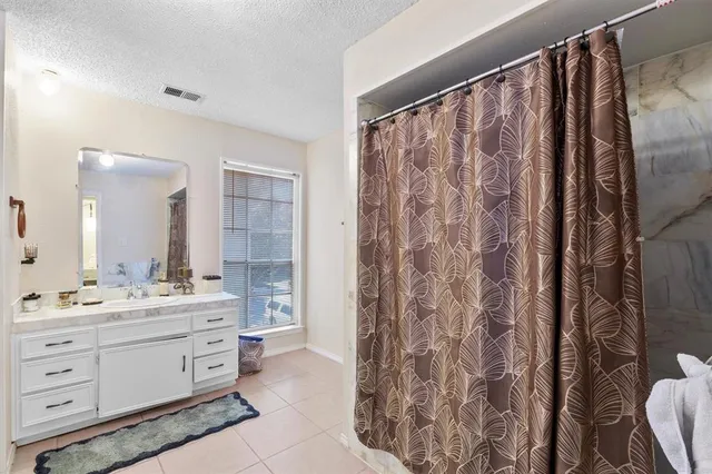a bathroom with a double vanity sink toilet mirror and shower