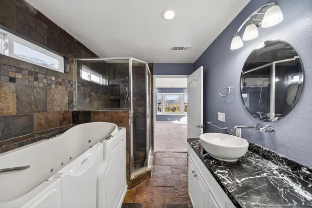 a bathroom with a granite countertop sink and mirror