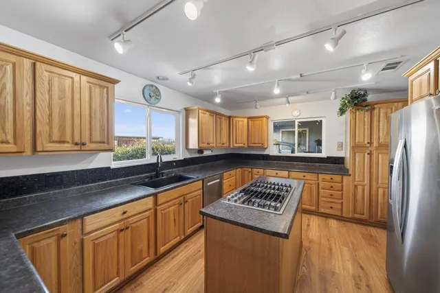 a kitchen with stainless steel appliances granite countertop a refrigerator and a sink