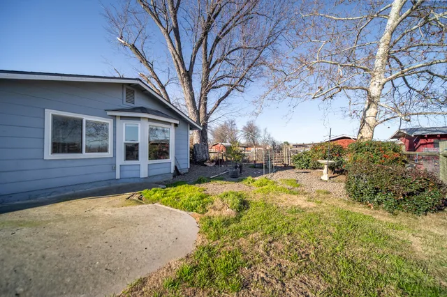 a view of a house with a big yard and potted plants