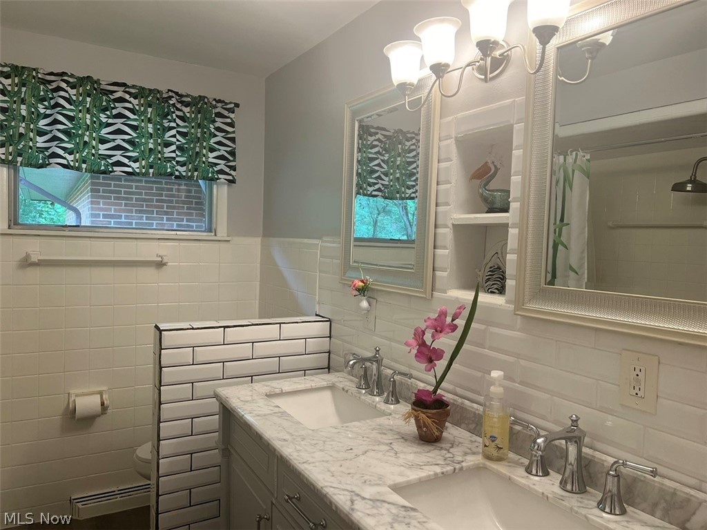 759 Truesdale Road Youngstown, OH 44511 - Photo 18 of 37 Bathroom featuring backsplash, a healthy amount of sunlight, tile walls, and double vanity
