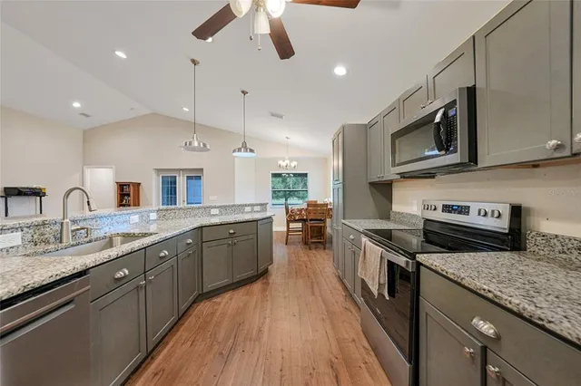 a large kitchen with stainless steel appliances granite countertop a stove and a sink