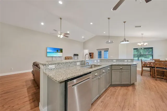 a kitchen with a sink dishwasher and a stove with wooden floor