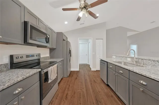 a kitchen with stainless steel appliances granite countertop wooden cabinets granite counter tops and a stove