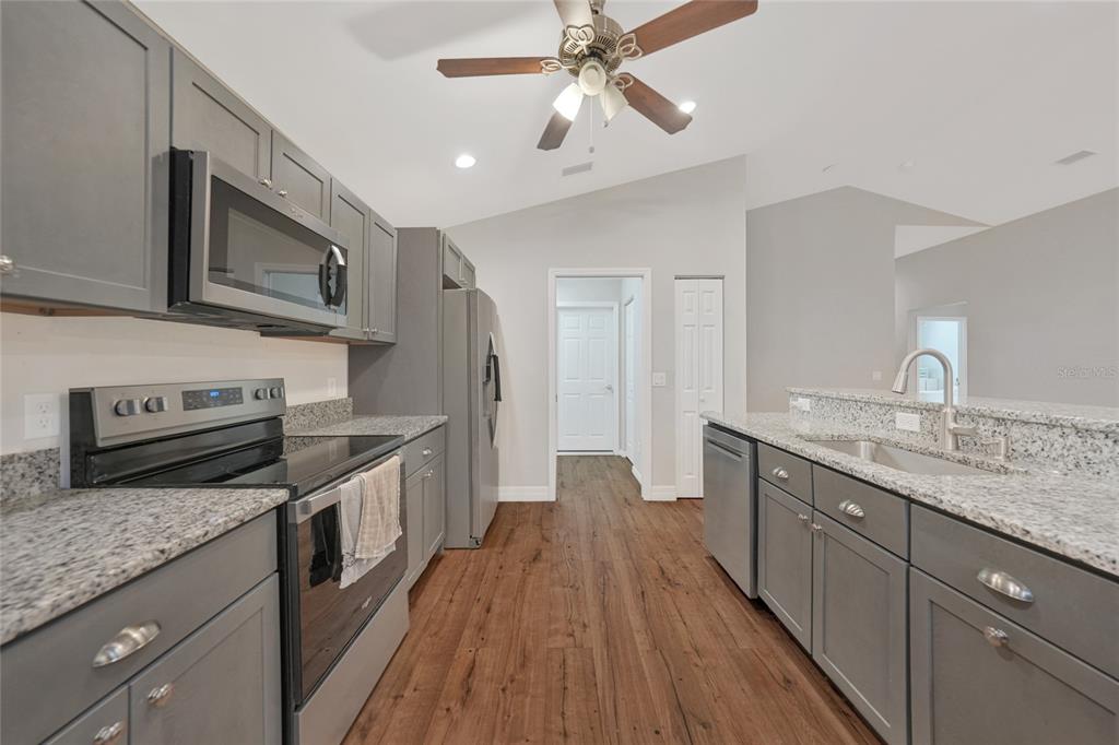 27234 Adams Street Punta Gorda, FL 33983 - Photo 17 of 29 a kitchen with stainless steel appliances granite countertop wooden cabinets granite counter tops and a stove