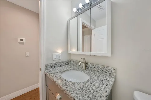 a bathroom with a granite countertop sink and a mirror