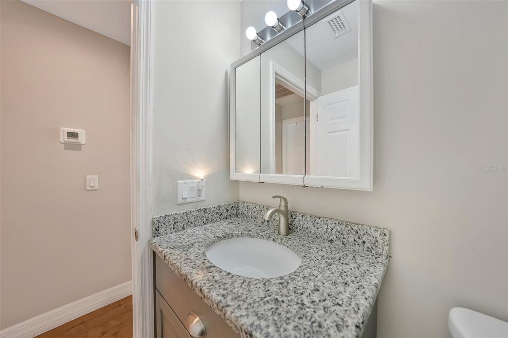 27234 Adams Street Punta Gorda, FL 33983 - Photo 9 of 29 a bathroom with a granite countertop sink and a mirror