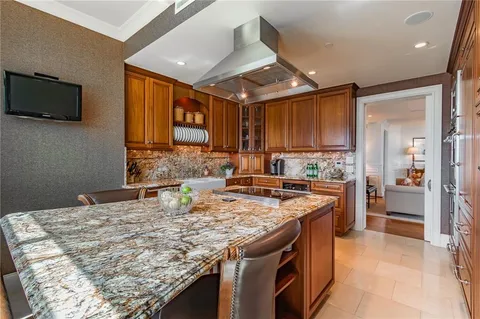 a kitchen with kitchen island granite countertop a sink stove and refrigerator