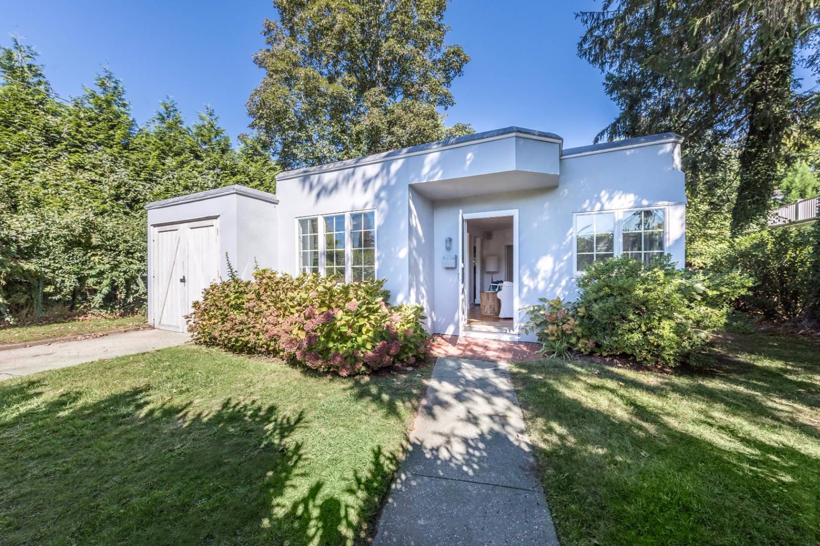 1 Sherrill Road East Hampton, NY 11937 - Photo 1 of 14 a front view of a house with a garden