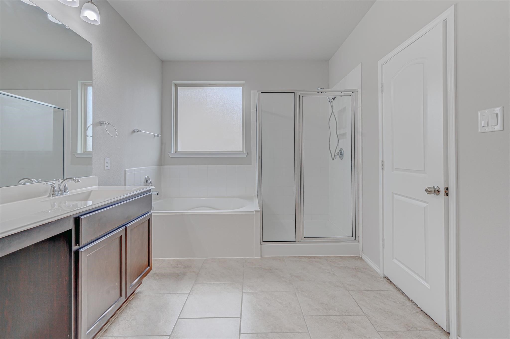 24311 North Newcastle Bay Trail Spring, TX 77389 - Photo 17 of 25 a spacious bathroom with a bathtub sink and mirror
