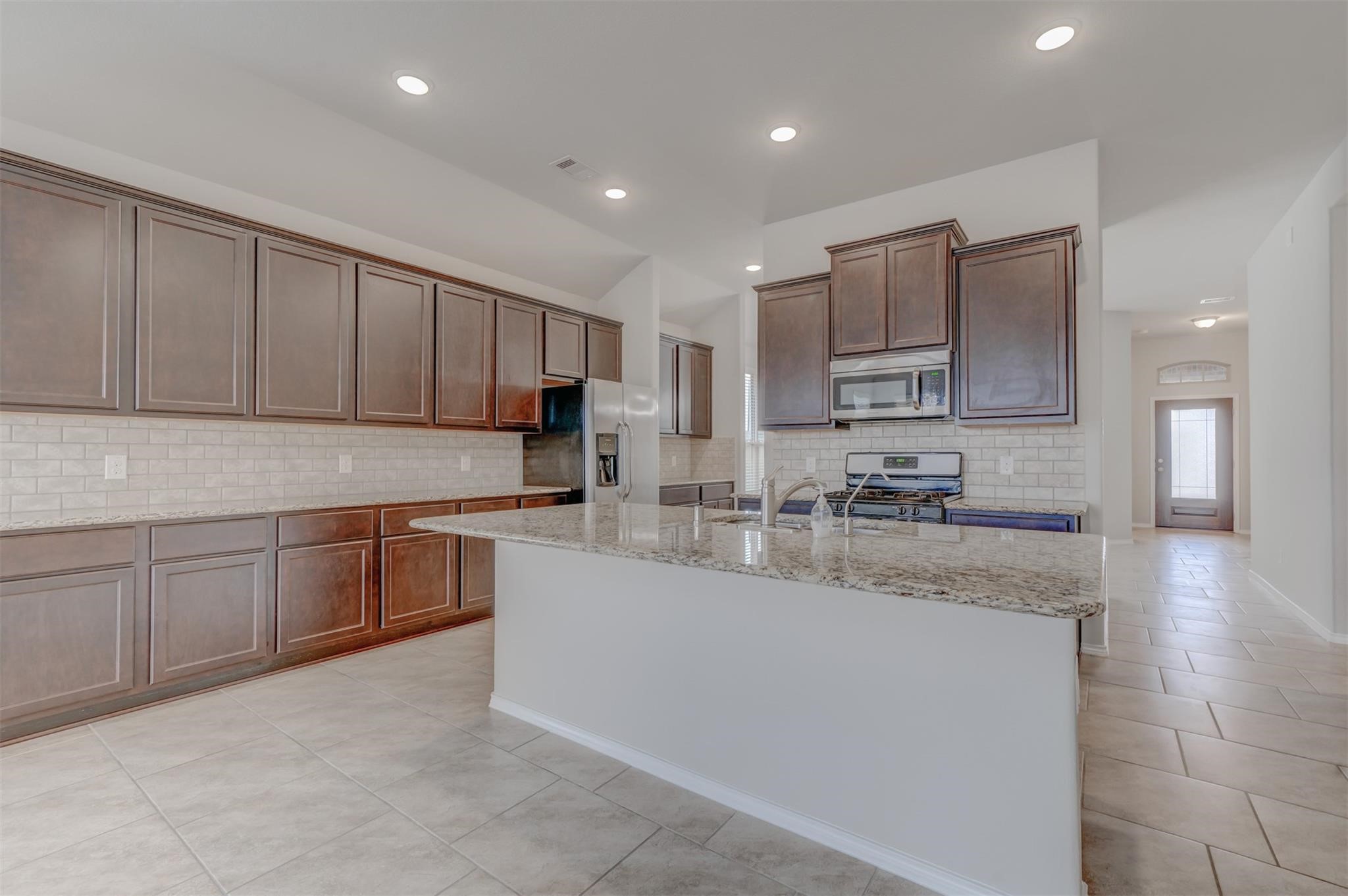 24311 North Newcastle Bay Trail Spring, TX 77389 - Photo 8 of 25 a kitchen with stainless steel appliances granite countertop a sink a stove a refrigerator and cabinets