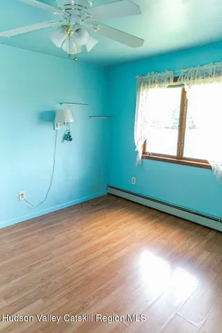 a view of a room with window wooden floor and front door