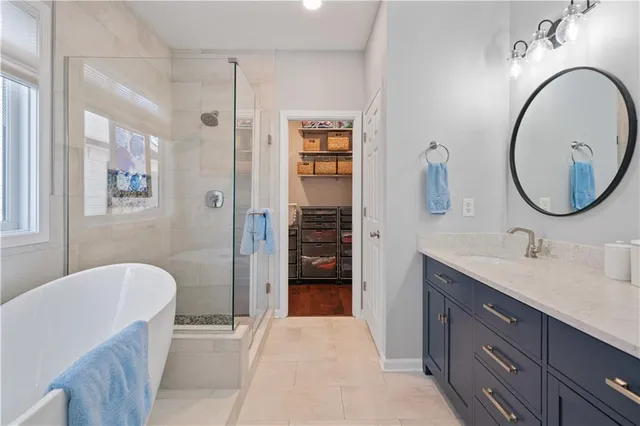 a en suite bathroom with a granite countertop tub sink and mirror