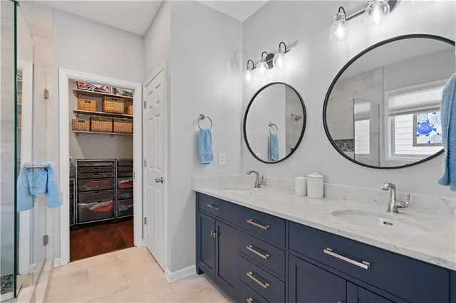 a en suite bathroom with a granite countertop double vanity sink and a mirror