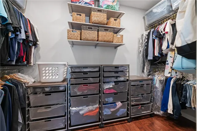 a view of walk in closet with clothes and shoes