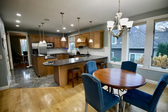 a kitchen with kitchen island a dining table and chairs