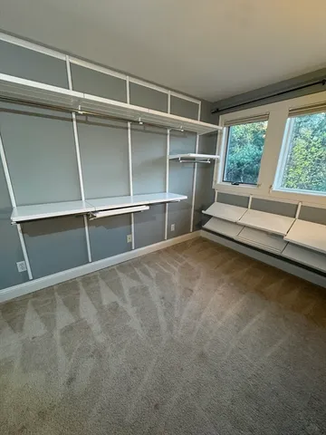 a living room with a large window and a rug