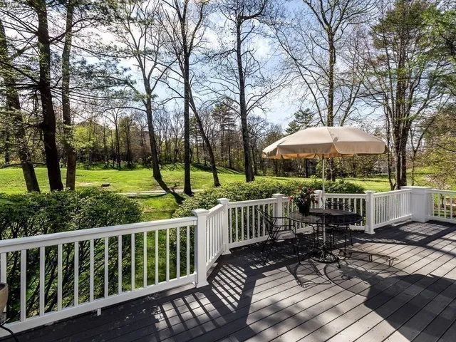 a view of a wooden deck with chairs and a yard