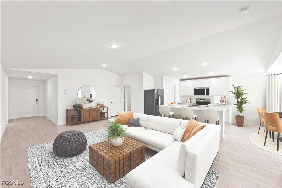 1219 Ecclus Street East Lehigh Acres, FL 33974 - Photo 2 of 8 a living room with furniture a couch and a view of kitchen