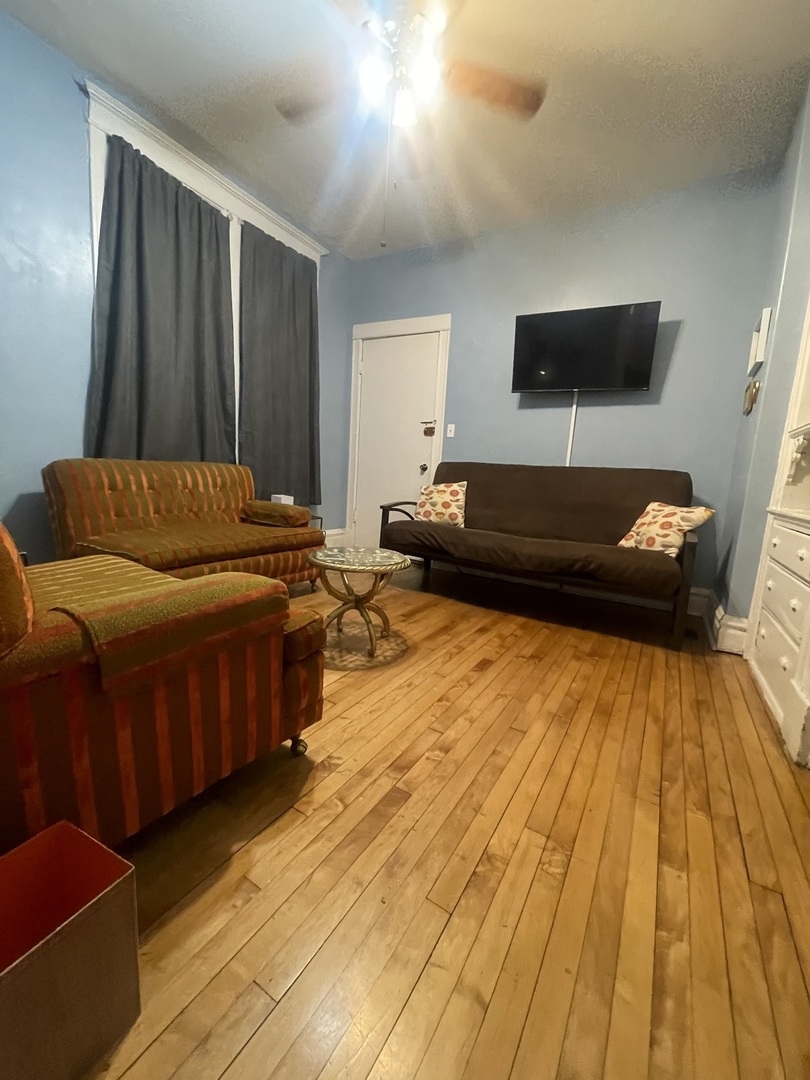 2107 West Coulter Street, Unit 1R Chicago, IL 60608 - Photo 15 of 26 a living room with a couch and a flat screen tv