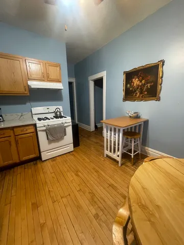 a living room with a sink and a wooden floor