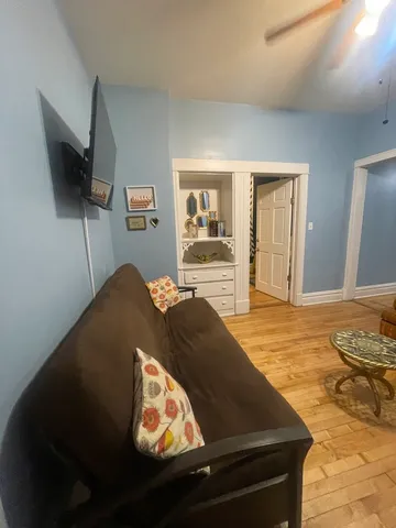 a living room with a bed furniture and a flat screen tv