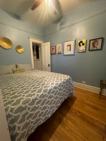 a bedroom with a bed and painting on the wall