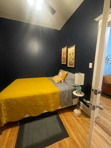 a bedroom with a bed and wooden floor