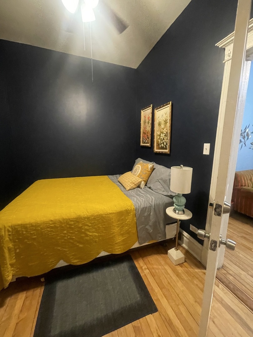 2107 West Coulter Street, Unit 1R Chicago, IL 60608 - Photo 23 of 26 a bedroom with a bed and wooden floor