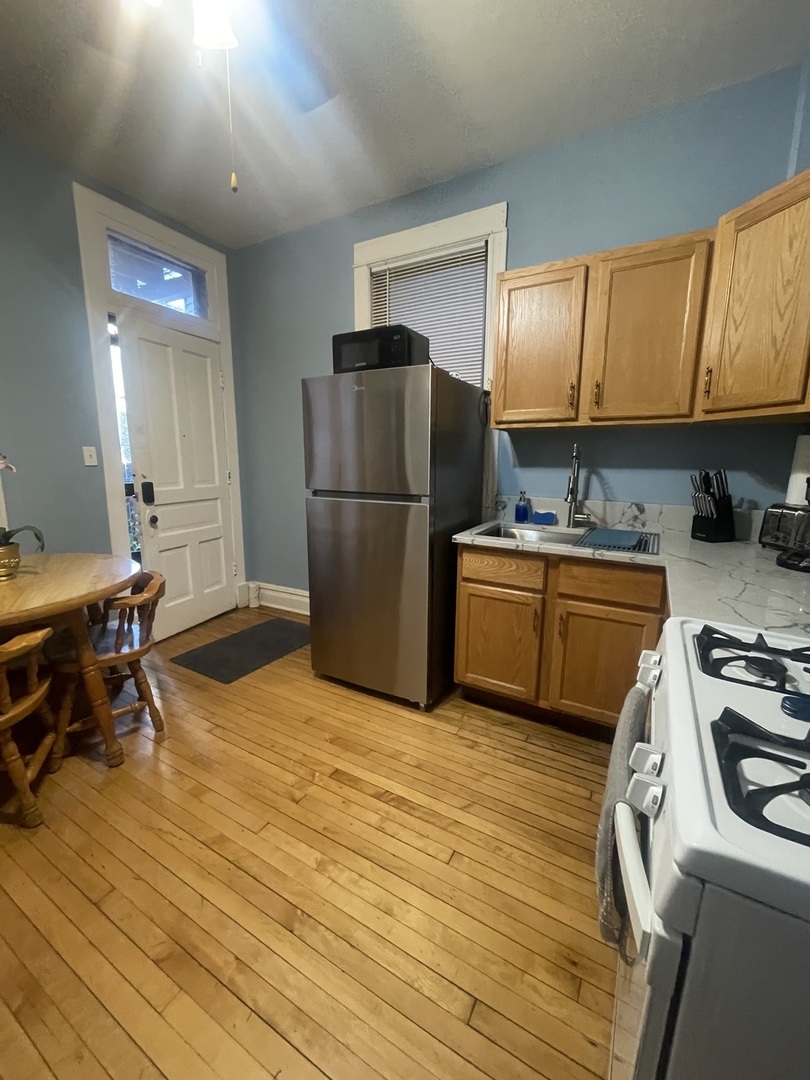 2107 West Coulter Street, Unit 1R Chicago, IL 60608 - Photo 3 of 26 a kitchen with a sink a stove and a refrigerator