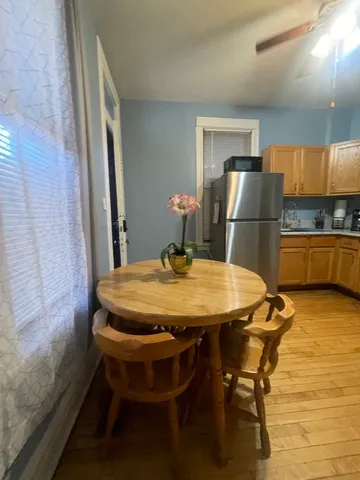 a kitchen with stainless steel appliances dining table chairs and wooden floor