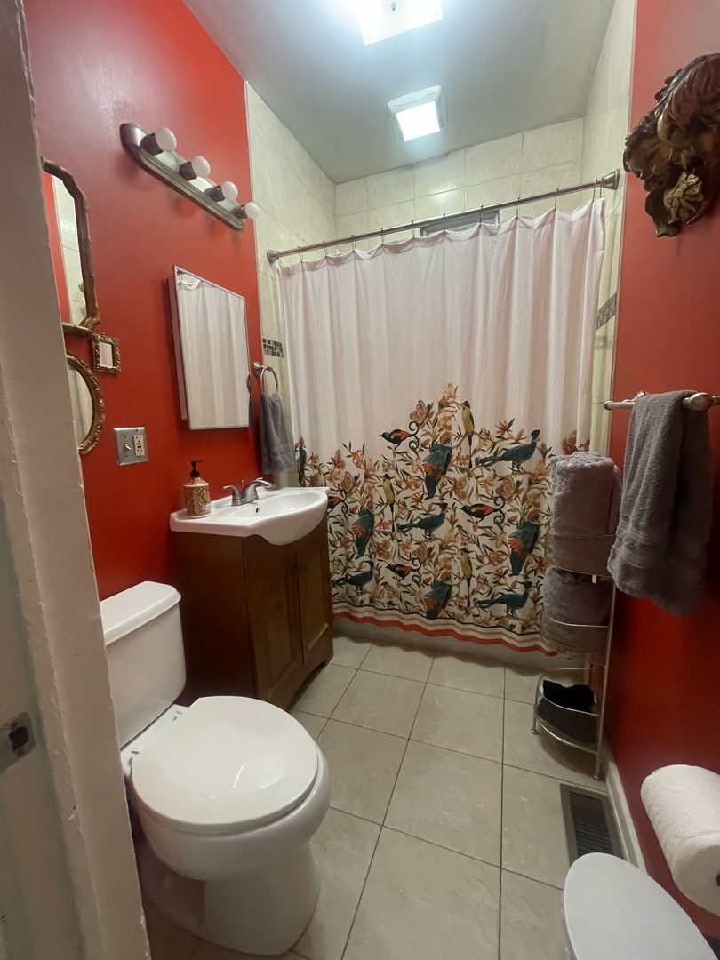 2107 West Coulter Street, Unit 1R Chicago, IL 60608 - Photo 9 of 26 a bathroom with a toilet sink and mirror