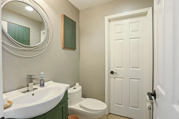 a bathroom with a sink a toilet and a mirror