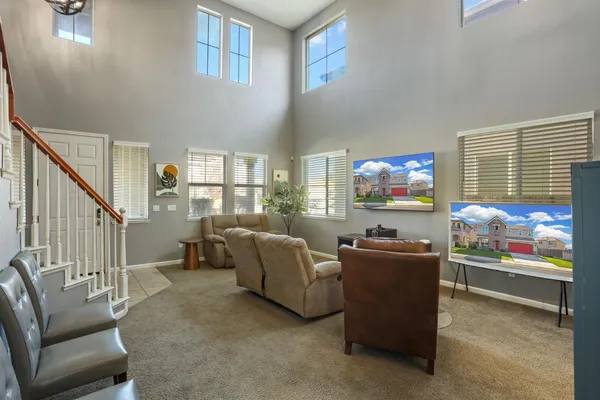 a living room with furniture a flat screen tv and a floor to ceiling window