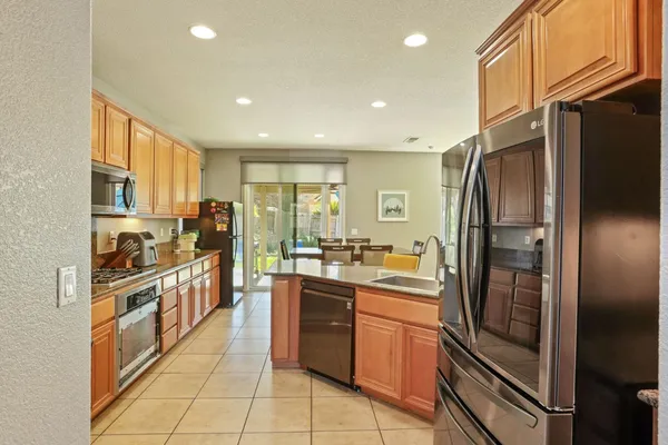 a kitchen with stainless steel appliances granite countertop a refrigerator and a stove