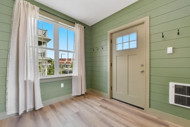 a view of an empty room with a window and wooden floor
