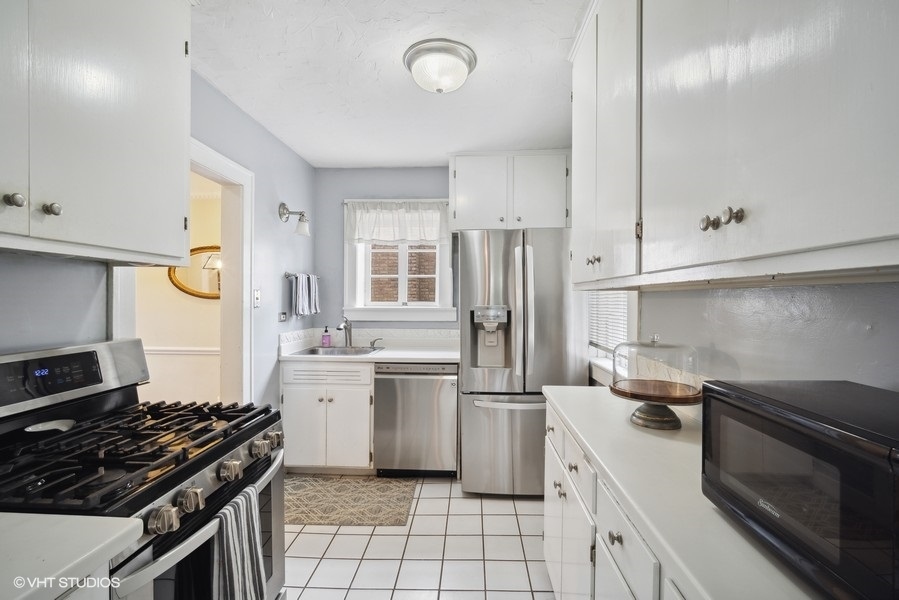 2129 Illinois Road Northbrook, IL 60062 - Photo 6 of 20 a kitchen with white cabinets and appliances