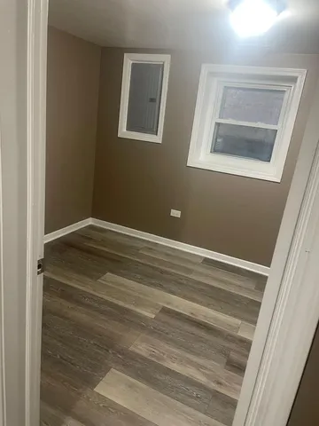 a view of a room with wooden floor and cabinet