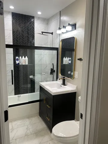 a bathroom with a sink a toilet and shower